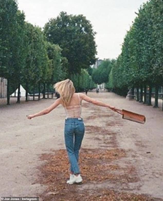 Wedded bliss: Joe Jonas, 30, posted a Valentine's Day tribute to his wife Sophie Turner, 23, with a photo of her happily swinging a bag while walking down a tree-lined path amid reports they are expecting their first child