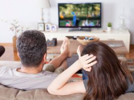 young couple watching tv at living room