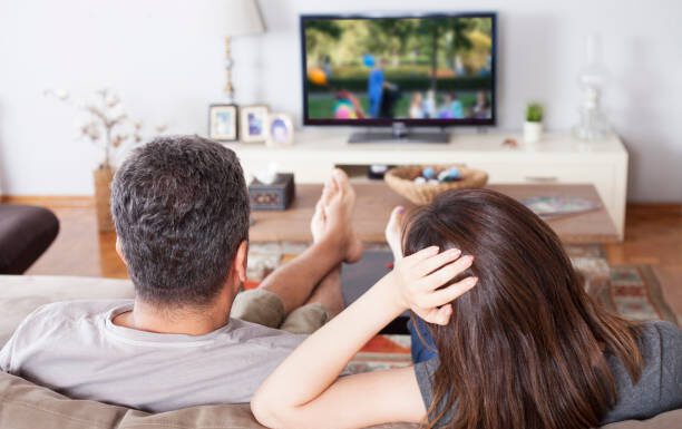 young couple watching tv at living room